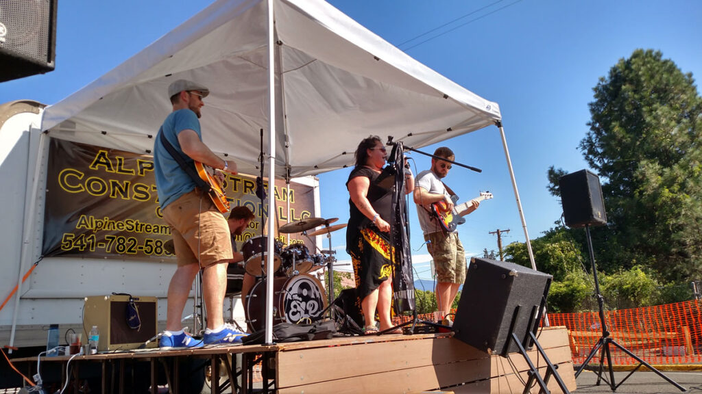 Oakridge, Oregon Keg & Cask Festival: 3 musicians performing under tent canopy